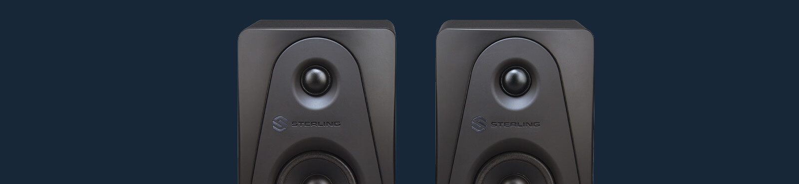 Sterling Audio MX3 3-inch powered studio monitor pair front top on wide blue background close up.